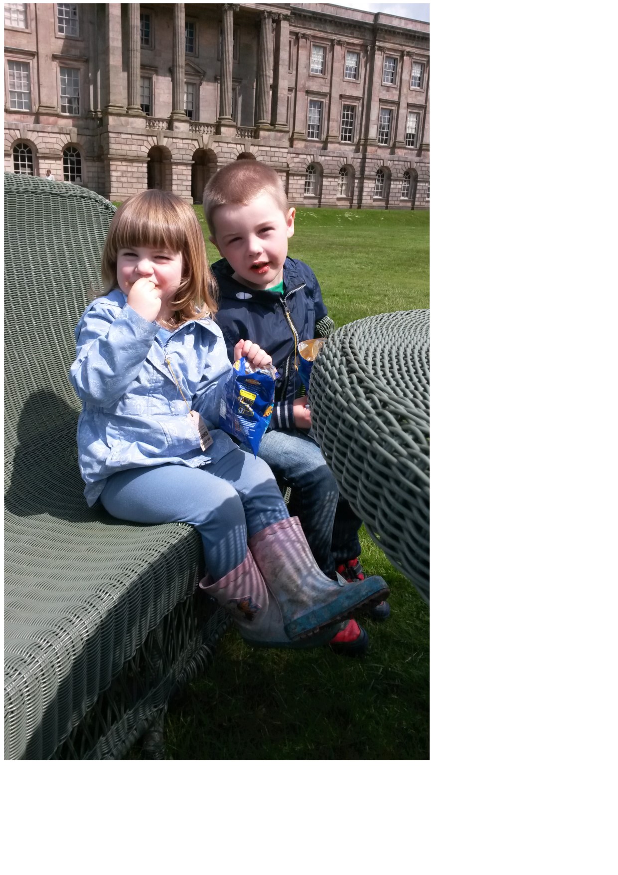 girl and boy sitting in garden sign